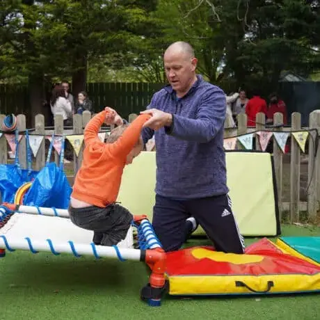 Staff supporting child on trampoline Staff supporting child on trampoline